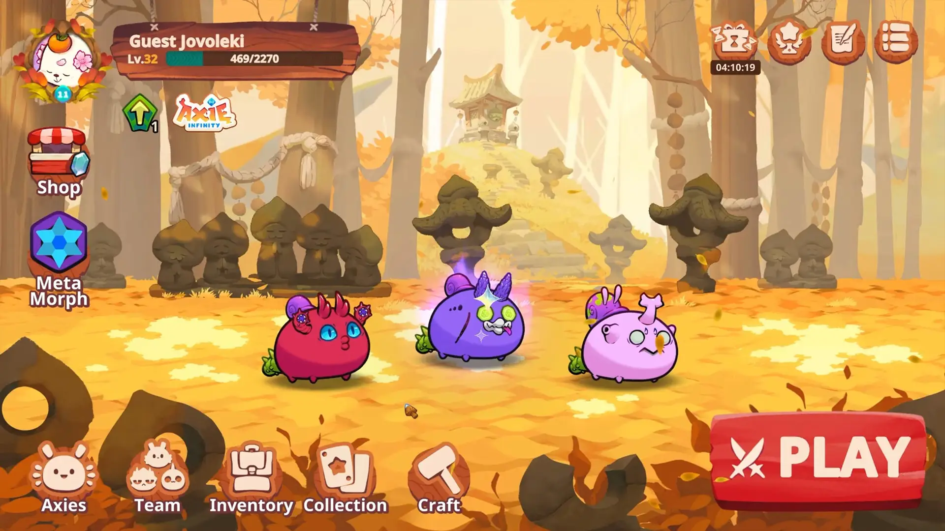 في لعبة Axie Infinity، تظهر ثلاثة كائنات كرتونية ملونة في بيئة غابة خريفية تحتوي على أشجار ذات أوراق ذهبية ومصابيح حجرية تقليدية على طول المسار، حيث يقف اللاعب "Guest Jovoleki" في المستوى 32 أمام شاشة تتضمن خيارات مثل المتجر والتمويه وقائمة الأوكسيات وزر اللعب الكبير.